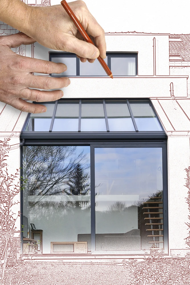 Mains masculines dessinant au crayon sur plans d'architecture