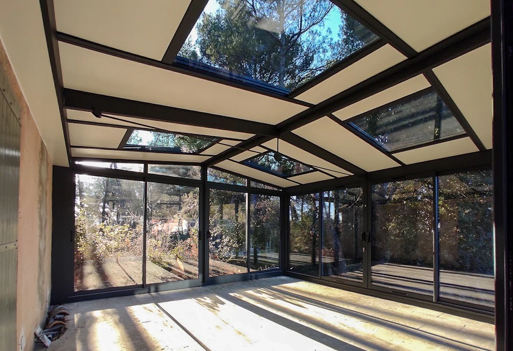 Terrasse extérieure couverte par une pergola moderne à structure métallique noire et toiture plate