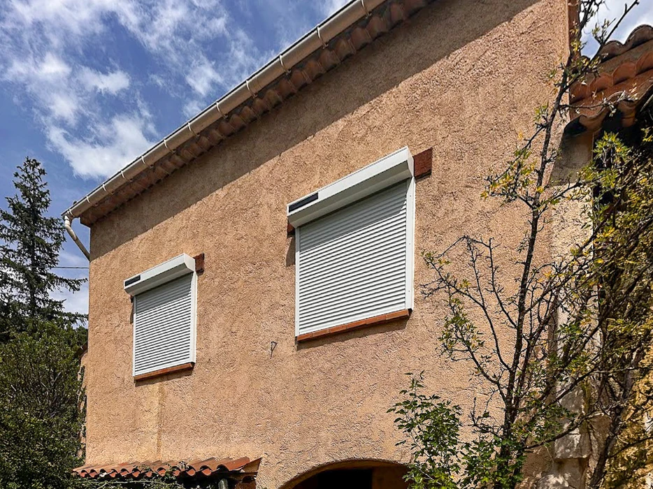 Véranda moderne avec structure aluminium et grandes baies vitrées coulissantes installée sur terrasse dallée