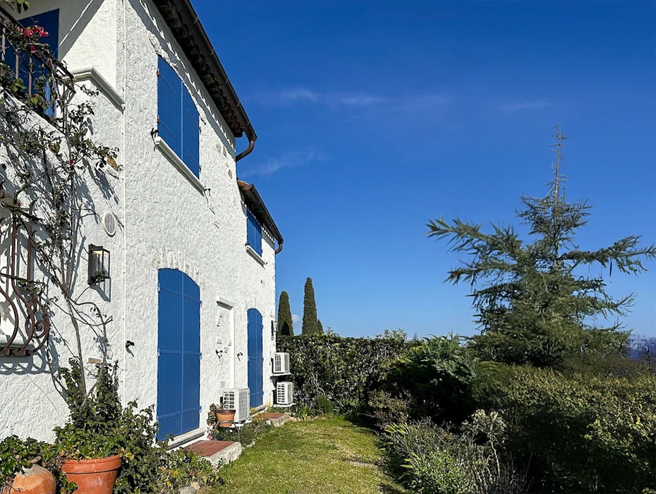Véranda moderne avec structure aluminium anthracite et baies vitrées coulissantes, aménagée en salle à manger sur terrasse bois
