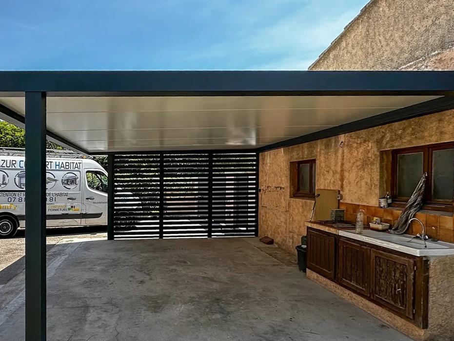 Véranda moderne avec structure aluminium et grandes baies vitrées coulissantes installée sur terrasse dallée