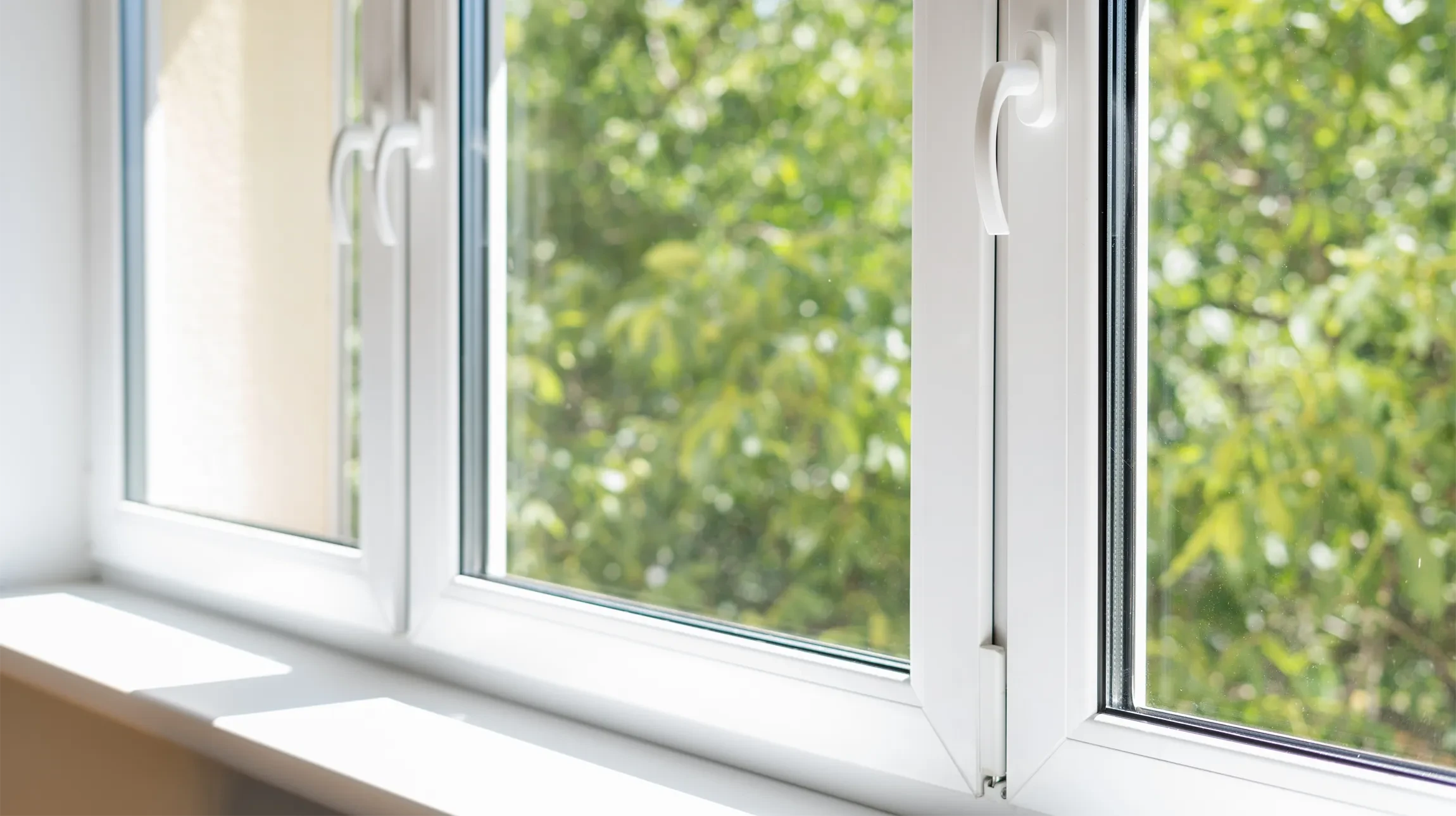 Homme en vêtements de travail bleus et casquette noire installant une fenêtre, mains gantées de blanc positionnées sur le vitrage