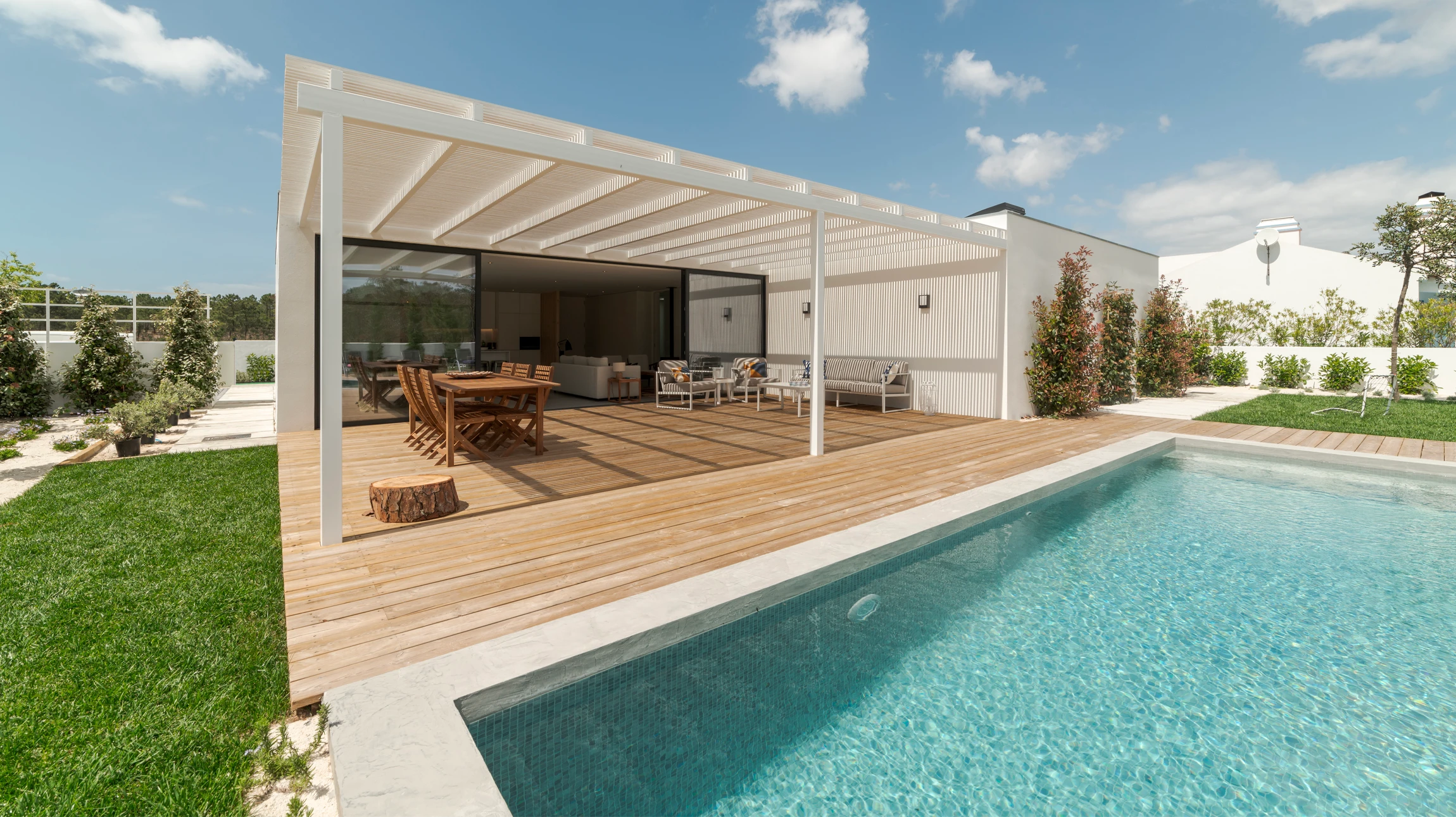 Maison contemporaine avec extension véranda vitrée dans jardin paysagé